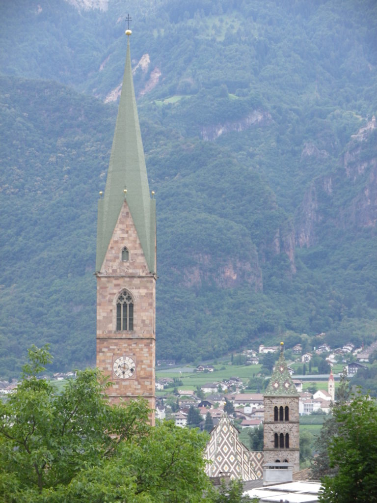 Contrasting Heights: Tall Steeples, Taller Mountains